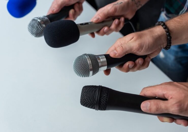 Close-up,Of,Four,Hands,Holding,Different,Microphones,,Suggesting,A,Press
