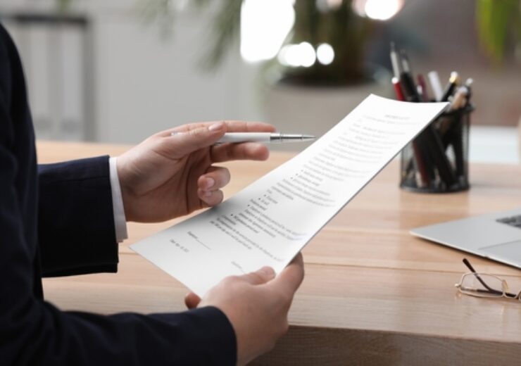 Man,Reading,Document,At,Table,In,Office,,Closeup.,Signing,Contract