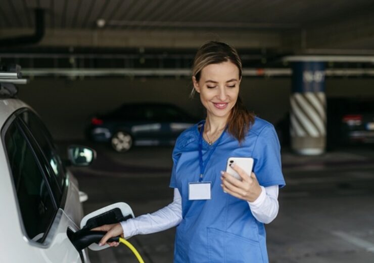 Nurse,Plugging,Charger,Into,Electric,Car,Before,Going,To,Work.