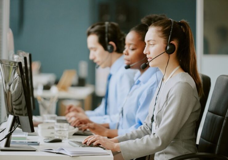 Young,Biracial,Call,Center,Operators,Sitting,At,Work,Desk,With
