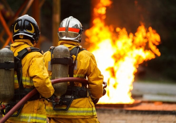 Firefighters,Team,Wearing,Full,Protective,Gear,Operate,Fire,Hose,To