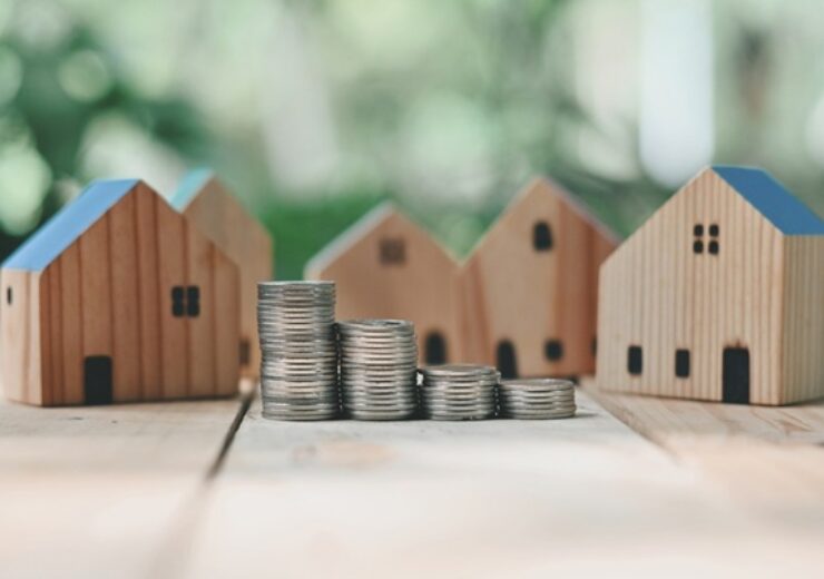 Close,Up,Stack,Of,Coin,And,Toy,Wooden,House,On